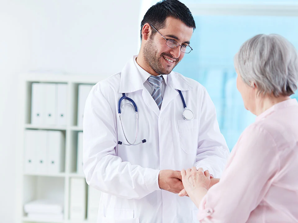 Médico atendiendo a una paciente con cercanía y confianza, reflejando cómo la interoperabilidad en salud mejora la calidad del servicio y la experiencia del paciente.